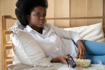 Full length of young woman sitting on sofa