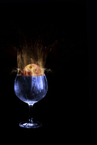 Close-up of wineglass against black background