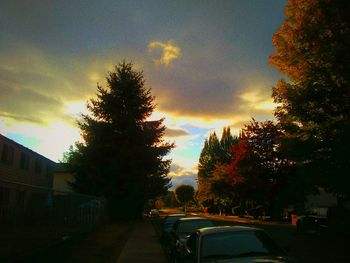 Cars on road against cloudy sky