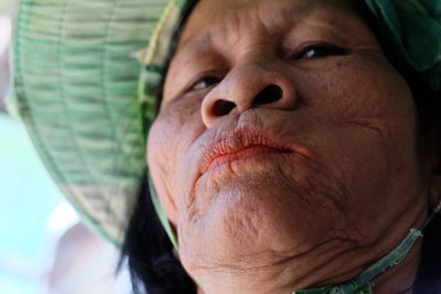 Close-up of senior woman wearing hat outdoors