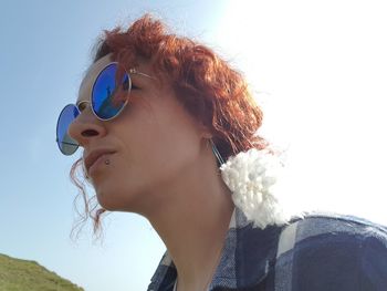 Close-up low angle view of woman looking away against sky