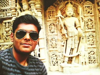 Man wearing sunglasses at temple