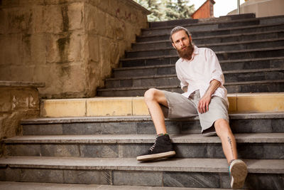 Portrait of young man sitting on steps