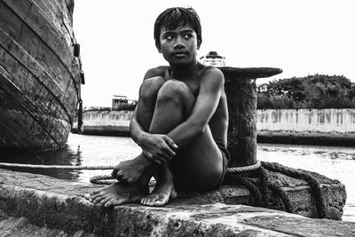 Young woman sitting on retaining wall