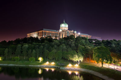 Illuminated buildings against sky at night