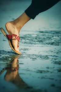 Low section of woman walking at beach