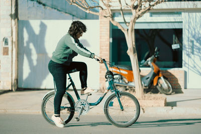 Trendy woman cycling in the street