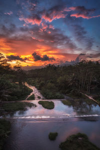 Scenic view of river against cloudy sky