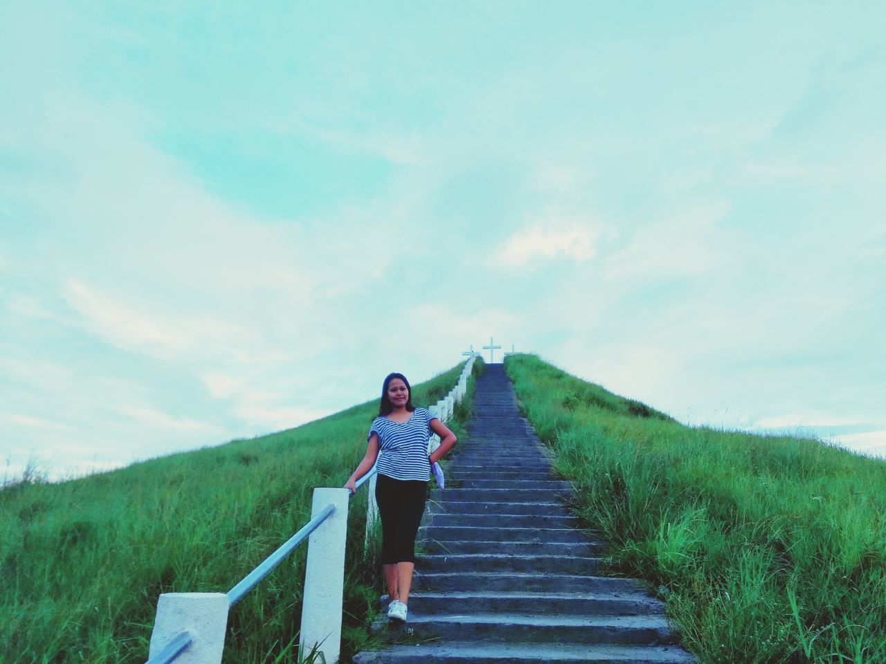 one person, sky, real people, direction, lifestyles, cloud - sky, leisure activity, the way forward, grass, day, full length, plant, casual clothing, nature, green color, standing, land, beauty in nature, tranquility, outdoors, diminishing perspective