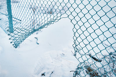 Close-up of snow covered fence against sky