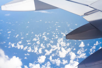 Aerial view of airplane wing over clouds