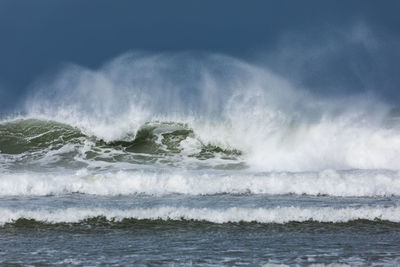 Wind whipping up waves as they break on the beach