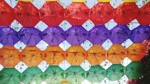 Low angle view of multi colored umbrellas hanging in row