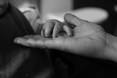 Cropped image of parent and baby hands