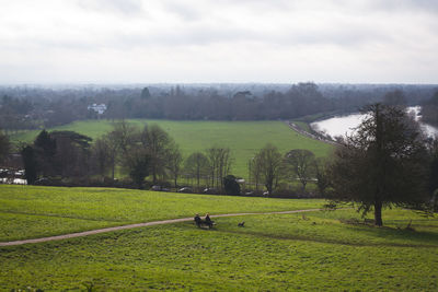 Scenic view of green landscape against cloudy sky