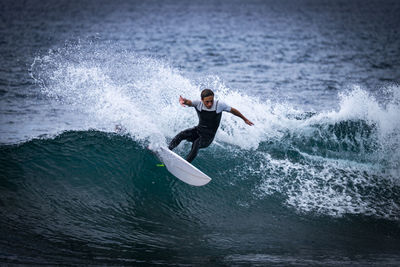 Teenage boy surfing in sea