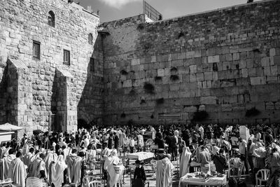 Group of people against brick wall in city