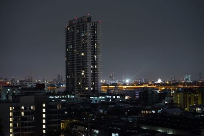 Illuminated buildings in city against sky at night