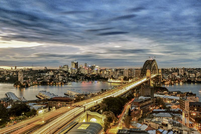 High angle view of illuminated city against cloudy sky