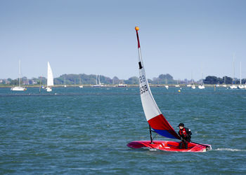 Boat sailing in sea against clear sky