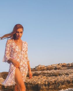 Young woman standing on land against clear sky