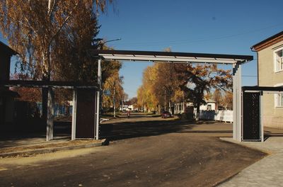 Street amidst trees and buildings against sky