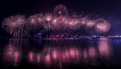 Firework display over river at night