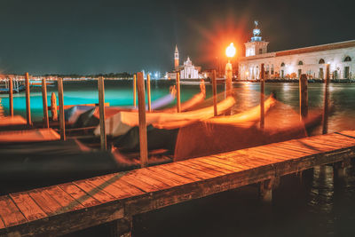 Boats moored in sea against sky at night