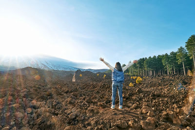 Woman enjoying freedom with open hands,while admiring panoramic view of snowy summit of volcano etna
