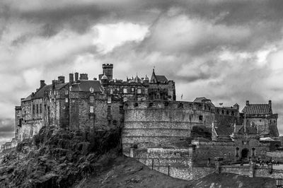Low angle view of old edinburgh castle against cloudy sky