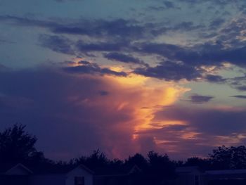 Low angle view of silhouette house against sky during sunset