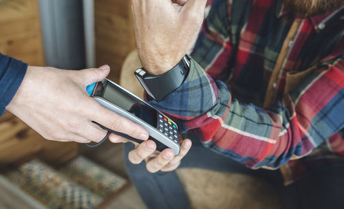 Man paying with smart watch in cafe