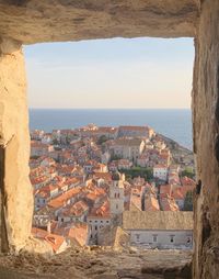 High angle view of townscape by sea against sky