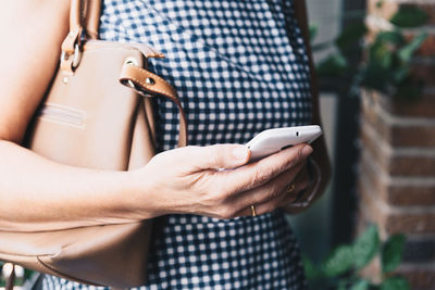 Midsection of woman holding smart phone