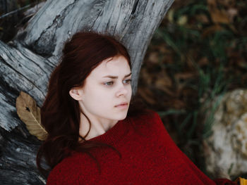 Portrait of a young woman with tree trunk