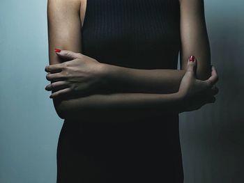 Midsection of woman standing on wall