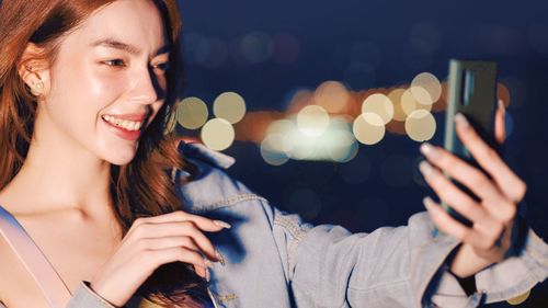 Portrait of woman using mobile phone at night