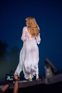 Rear view of woman statue against blue sky