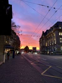 City street against sky at dusk