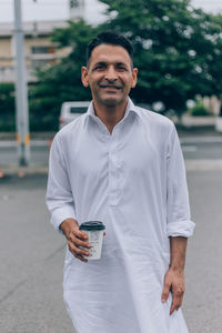 Portrait of smiling man standing in city