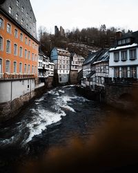 River flowing amidst buildings against sky