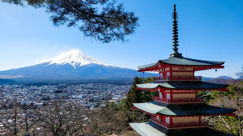 Traditional japanese chureito pagoda with mount fuji in the background with blue sky