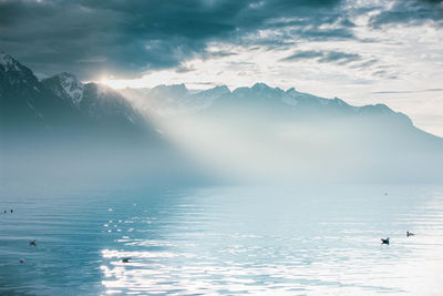 Scenic view of sea and mountains against sky