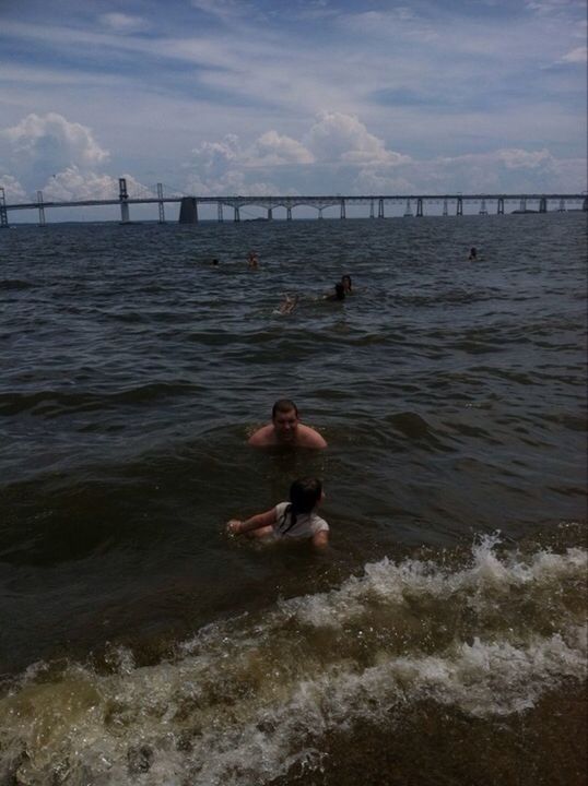 water, sea, waterfront, sky, lifestyles, leisure activity, rippled, cloud - sky, men, river, nature, dog, wave, full length, animal themes, swimming, bridge - man made structure, built structure