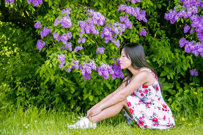 Side view of woman on pink flowering plants