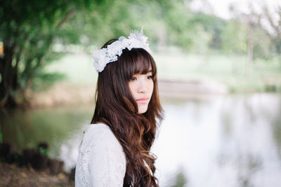 Woman looking away by lake in forest