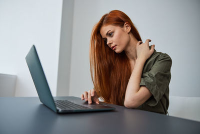 Young woman using laptop at table