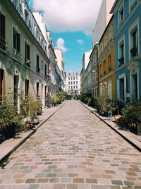 Footpath amidst buildings in city