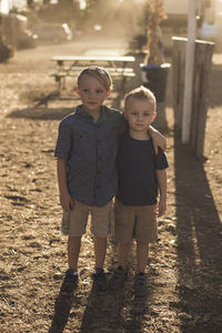 Confident brothers standing on field