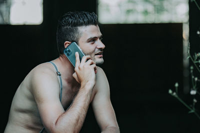 Side view of young man using mobile phone